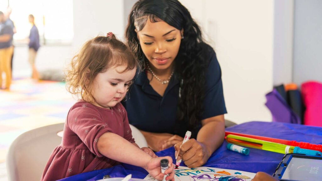 A child during creative play as part of an ABA therapy session for autism.