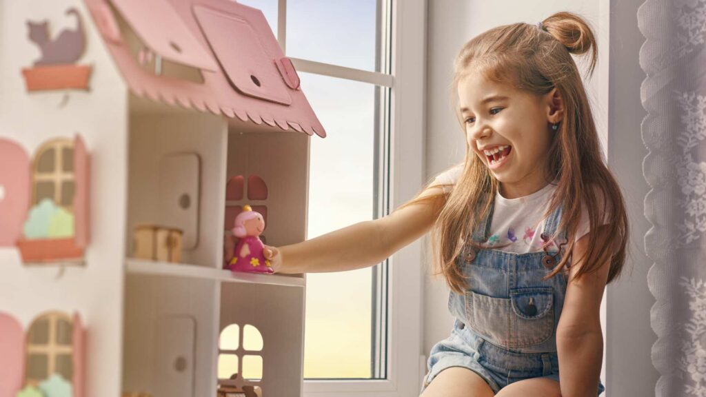 A child playing with a dollhouse reflects how simple moments of play can support ABA therapy. The image ties into the introduction of the Autistic Barbie, celebrating toys that embrace neurodiversity