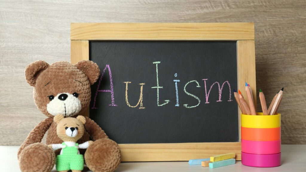 A cozy setup with teddy bears and an Autism chalkboard, symbolizing comfort and awareness