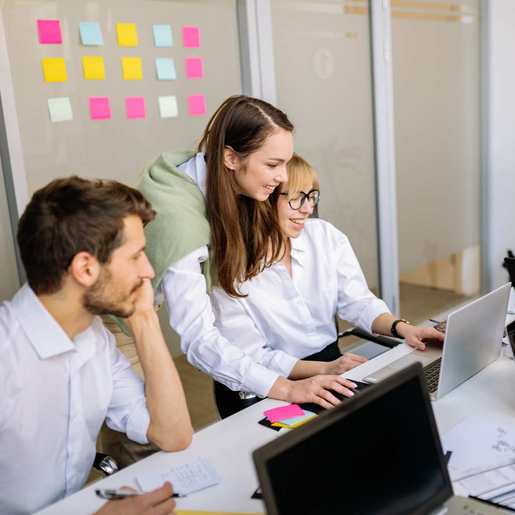 A group of coworkers collaborating at a table, showing a workplace that supports different communication needs