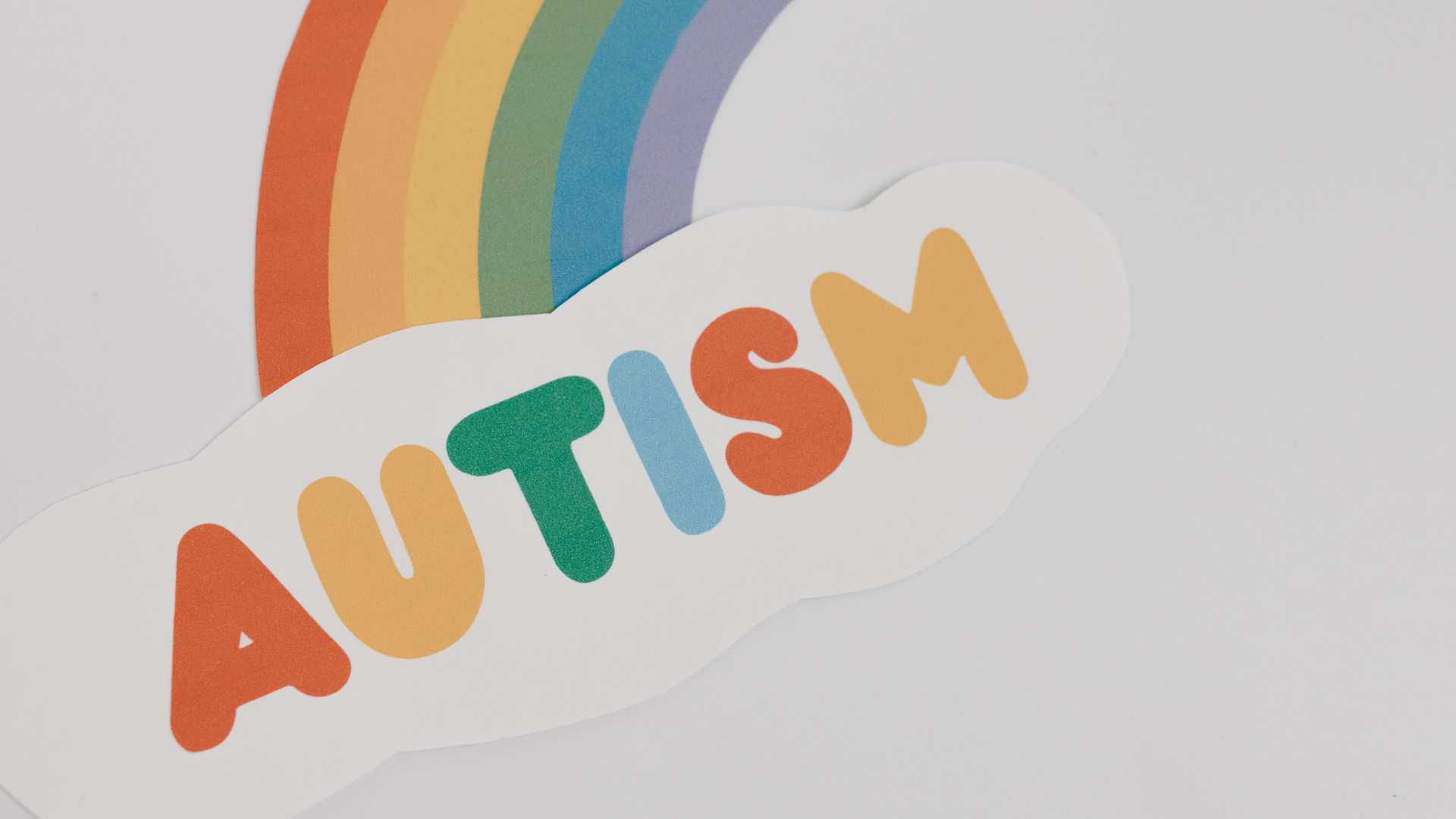 A rainbow and the word Autism in playful colors, a warm setting for exploring questions about autism.
