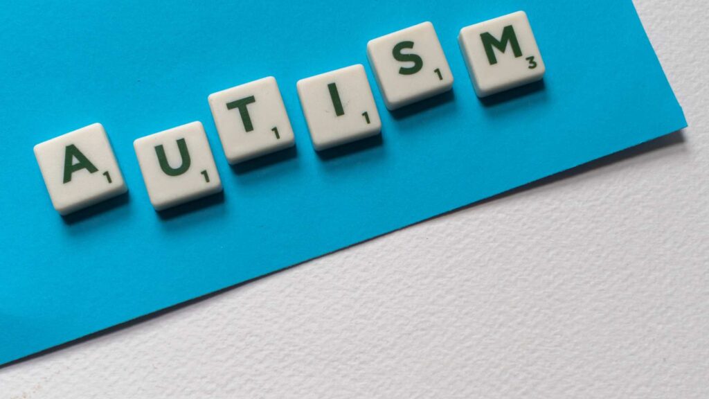 Tiles spelling “AUTISM”, used to illustrate the question “Am I on the spectrum”