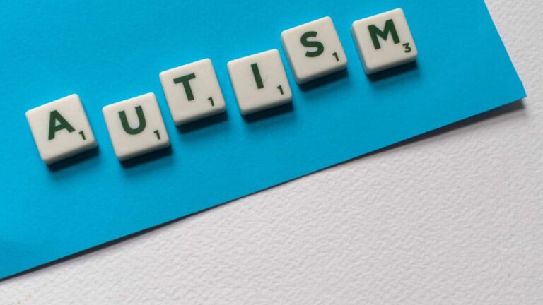 Tiles spelling “AUTISM”, used to illustrate the question “Am I on the spectrum”