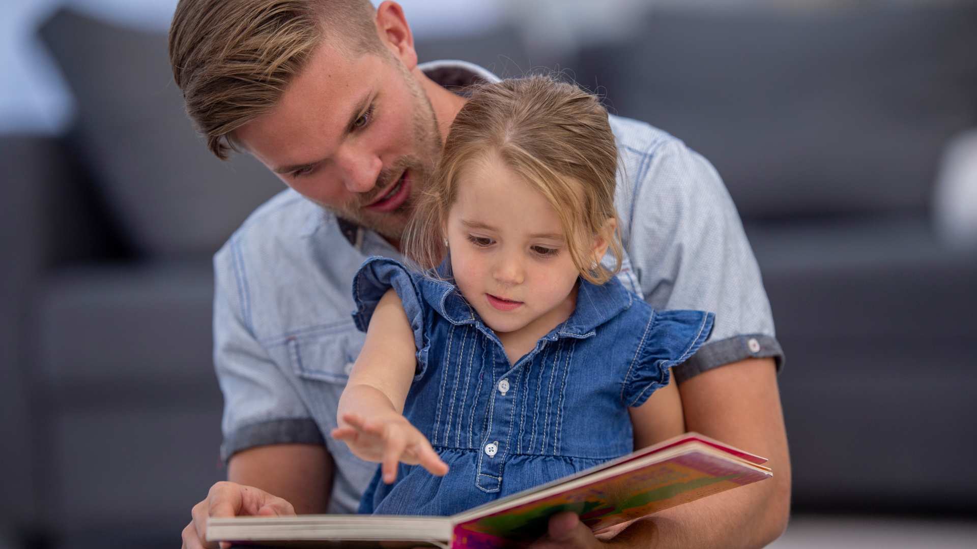 Parent reading a story with a young child to encourage learning